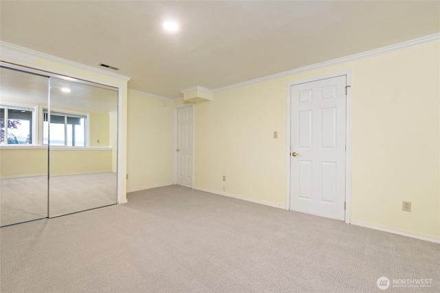 unfurnished bedroom featuring baseboards, visible vents, ornamental molding, and carpet