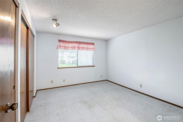 unfurnished bedroom with a closet, baseboards, carpet flooring, and a textured ceiling
