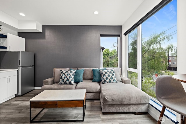 living area featuring an accent wall, recessed lighting, and wood finished floors