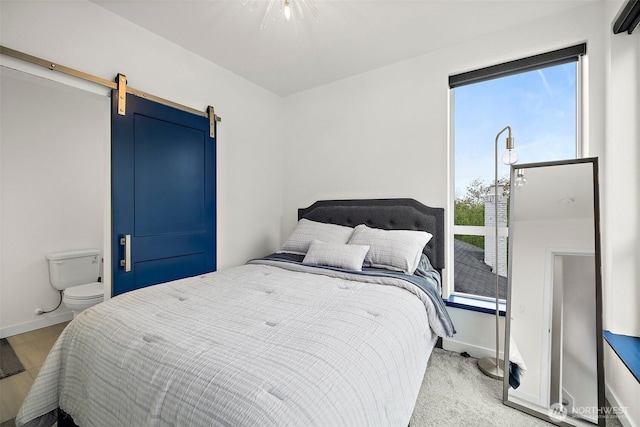 bedroom featuring baseboards and a barn door