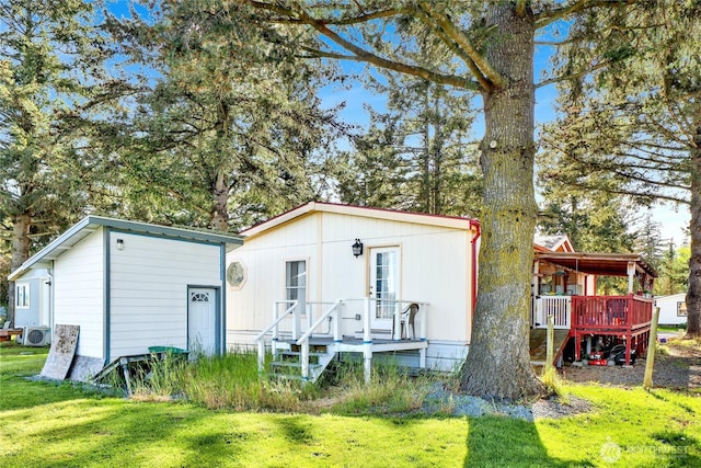 view of front of house with a front lawn, a cooling unit, and a deck
