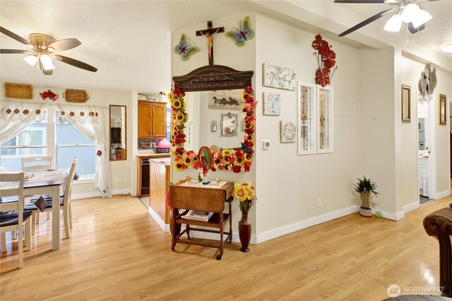hall with light wood-style flooring and baseboards