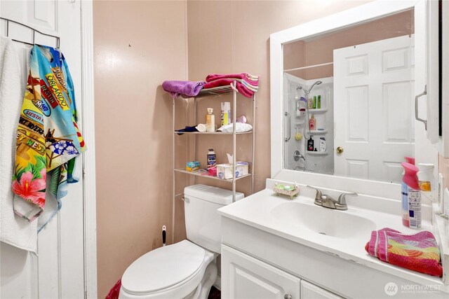 bathroom with vanity, a shower, and toilet