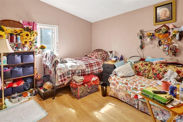 bedroom with wood finished floors and vaulted ceiling