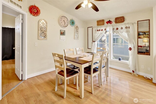 dining space featuring light wood finished floors, a ceiling fan, and baseboards