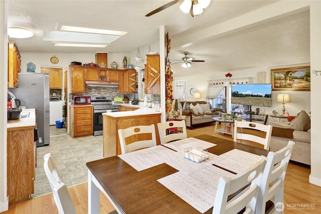 dining area featuring ceiling fan and a skylight