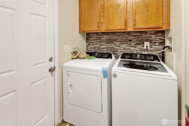 washroom with washer and clothes dryer and cabinet space