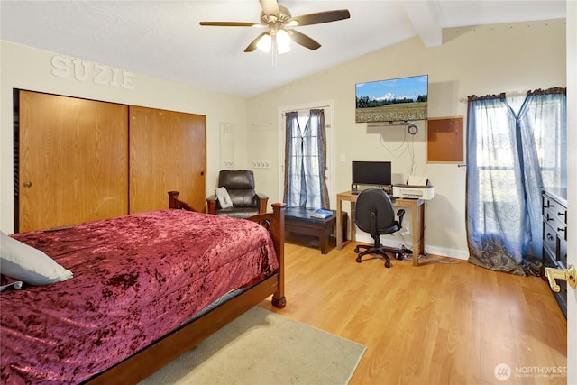 bedroom with light wood-style floors, an office area, baseboards, a closet, and a ceiling fan