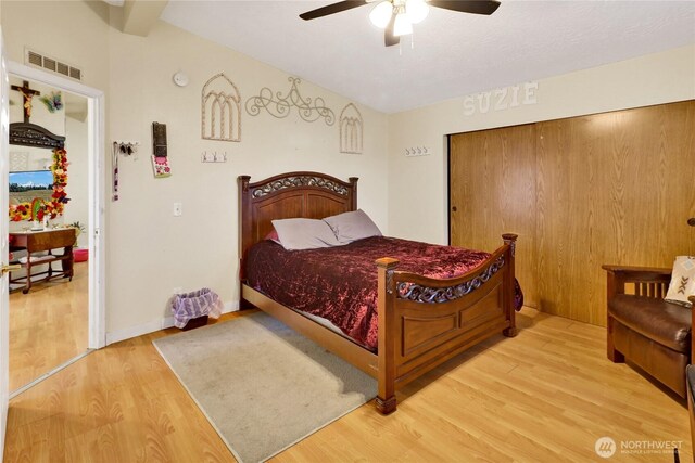 bedroom featuring wood finished floors, a ceiling fan, and a closet