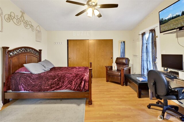 bedroom with light wood-type flooring, an office area, and ceiling fan