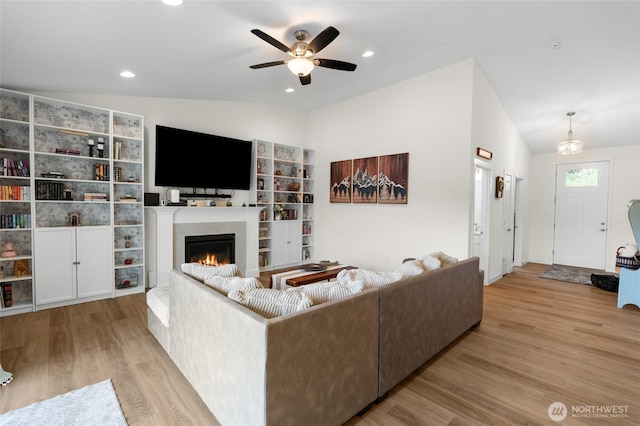 802 SE Cody St, Rainier, WA 98576 - living area featuring a warm lit fireplace, ceiling fan, wood finished floors, lofted ceiling, and recessed lighting