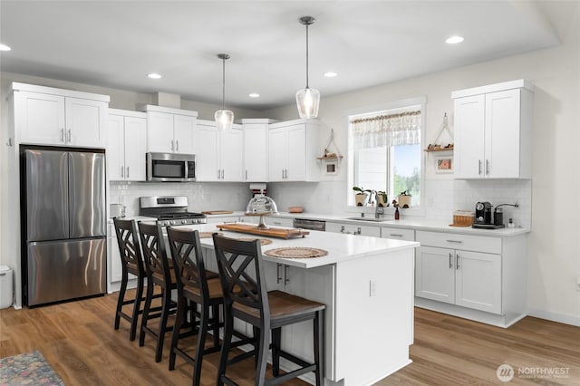 802 SE Cody St, Rainier, WA 98576 - kitchen featuring stainless steel appliances, a breakfast bar area, white cabinets, a center island, and recessed lighting