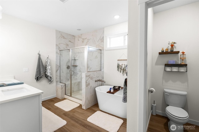 802 SE Cody St, Rainier, WA 98576 - bathroom featuring a marble finish shower, a soaking tub, wood finished floors, toilet, and double vanity