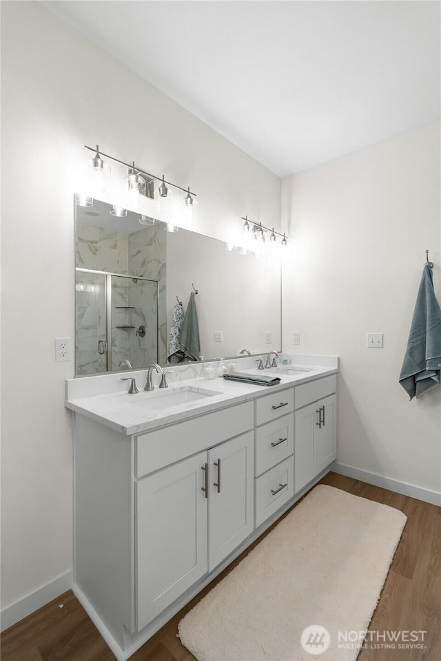 802 SE Cody St, Rainier, WA 98576 - bathroom with a marble finish shower, wood finished floors, double vanity, and baseboards