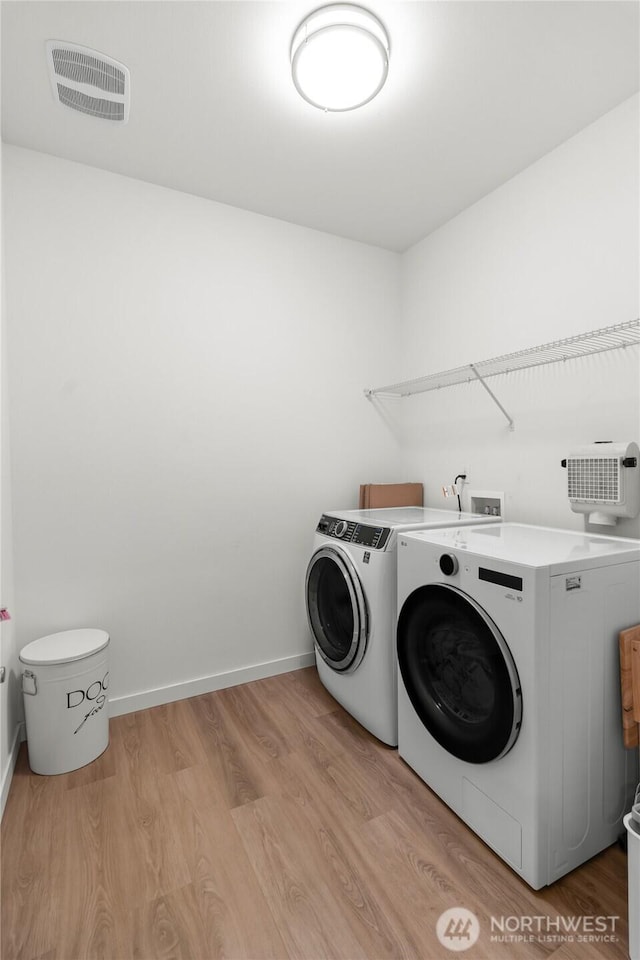 802 SE Cody St, Rainier, WA 98576 - laundry area with washing machine and dryer, light wood finished floors, and baseboards