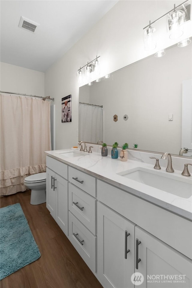 802 SE Cody St, Rainier, WA 98576 - bathroom with wood finished floors, toilet, double vanity, and curtained shower