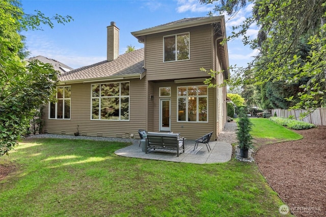 back of property with fence, a chimney, a yard, and a patio area