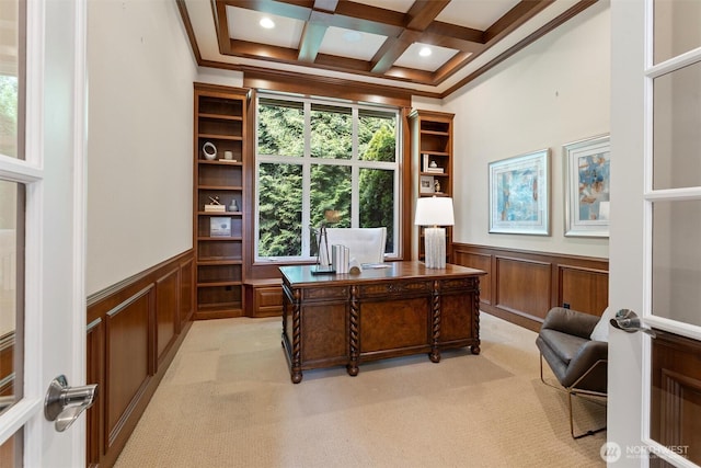 office space with a decorative wall, wainscoting, beam ceiling, and light carpet