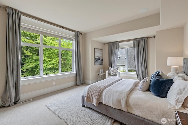 bedroom with baseboards, visible vents, and carpet