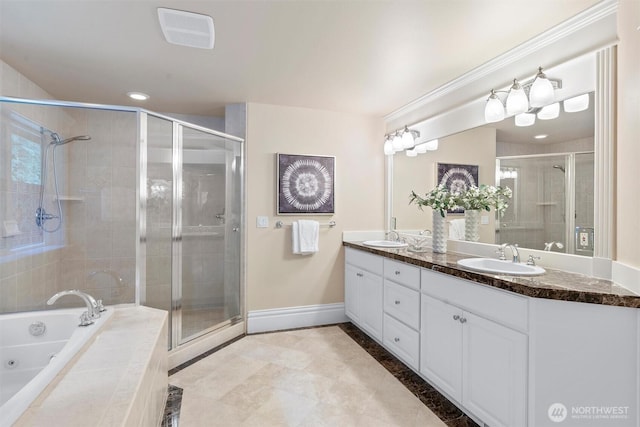 full bathroom with baseboards, a sink, double vanity, and a shower stall