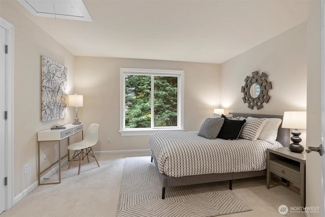bedroom with baseboards, light carpet, and attic access