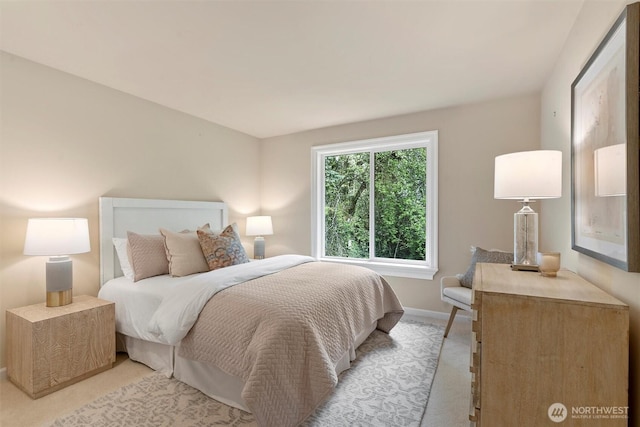 bedroom featuring baseboards and light carpet