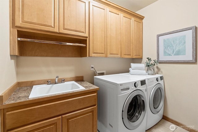 clothes washing area with a sink, cabinet space, and washer and clothes dryer