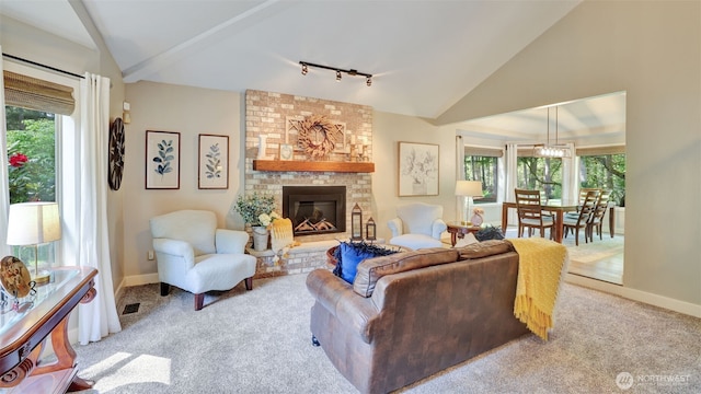 carpeted living room featuring track lighting, baseboards, a brick fireplace, and lofted ceiling
