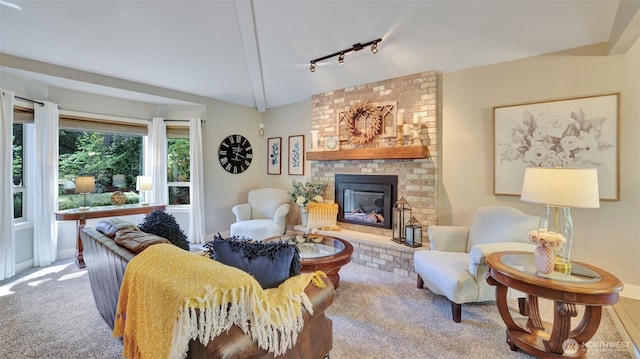 carpeted living room featuring baseboards, track lighting, and a fireplace