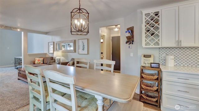dining area featuring a notable chandelier and light carpet