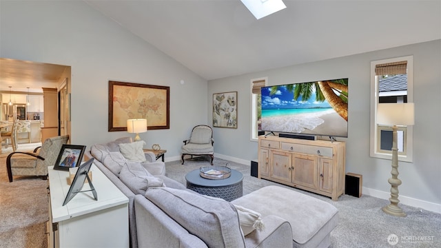 living area featuring a skylight, baseboards, high vaulted ceiling, and light colored carpet