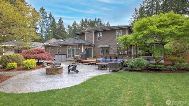 back of property with a lawn, an outdoor living space with a fire pit, a patio area, and a deck