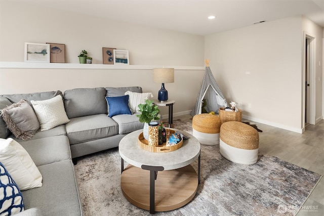living room featuring baseboards, recessed lighting, wood finished floors, and visible vents