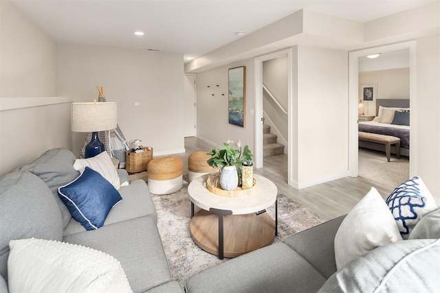 living area featuring recessed lighting, baseboards, stairway, and light wood-type flooring