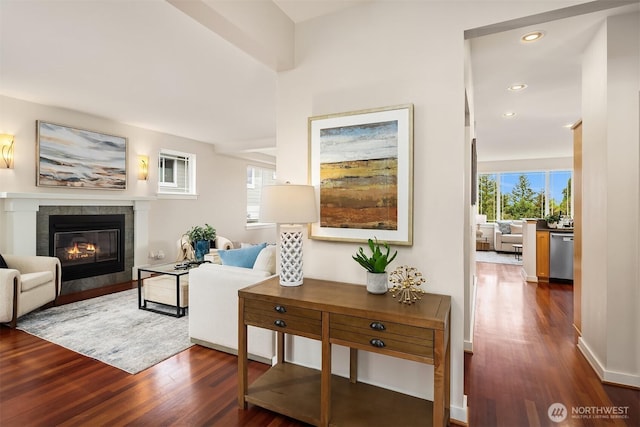 living room featuring recessed lighting, dark wood-style floors, a wealth of natural light, and a tiled fireplace