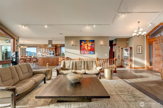 interior space with baseboards, an inviting chandelier, and rail lighting