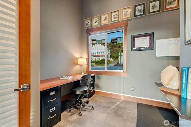 office featuring baseboards, tile patterned floors, and built in desk