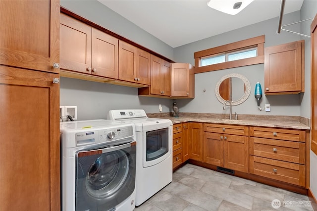 clothes washing area featuring separate washer and dryer, cabinet space, and a sink