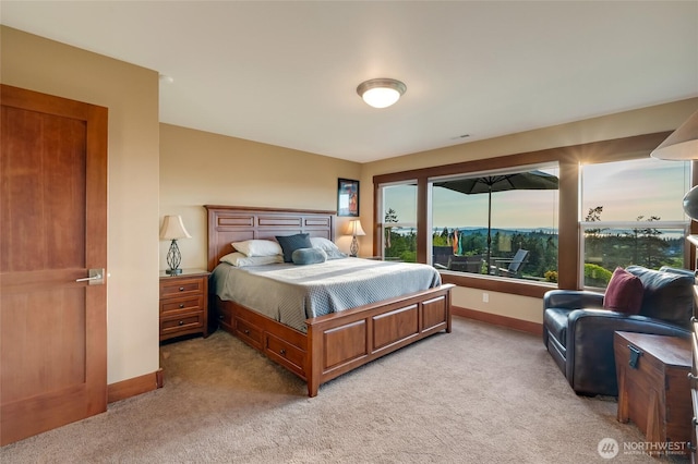 bedroom featuring light colored carpet and baseboards