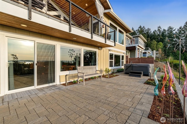 view of patio / terrace featuring a balcony and a hot tub