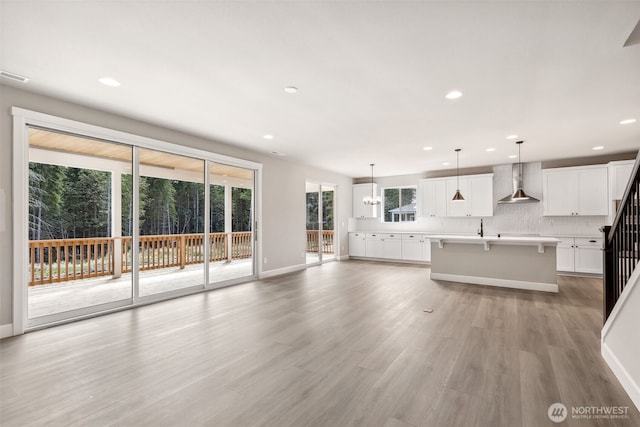 unfurnished living room featuring visible vents, recessed lighting, light wood-style floors, and a sink