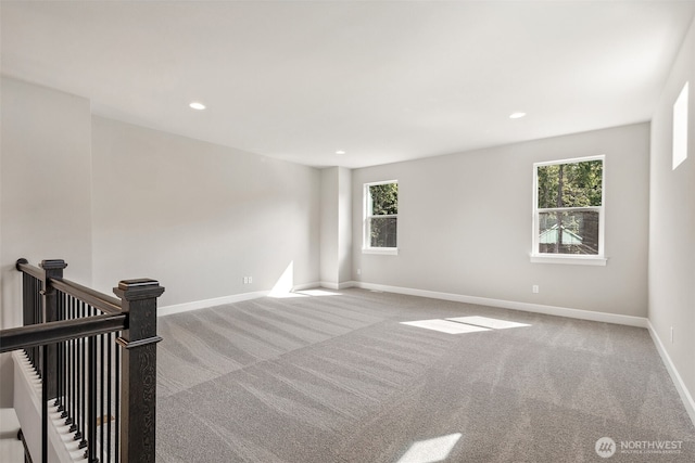 carpeted spare room with a healthy amount of sunlight, recessed lighting, and baseboards