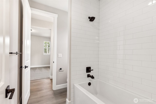 full bath with baseboards, wood finished floors, and shower / bathtub combination
