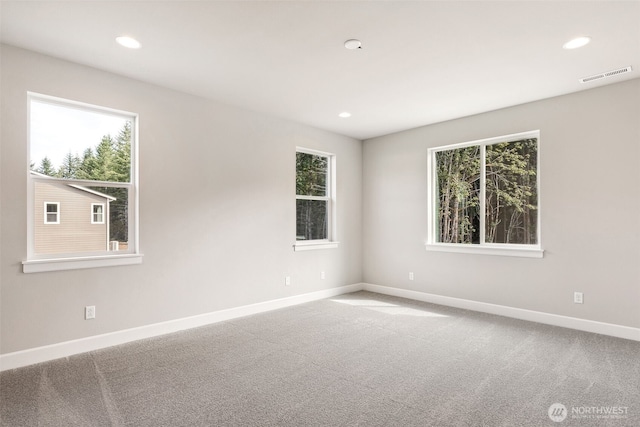 carpeted empty room featuring recessed lighting, visible vents, and baseboards