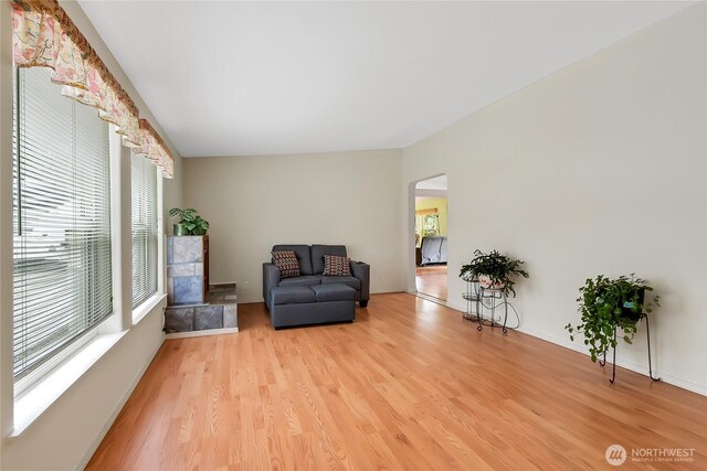 living area with light wood-type flooring, arched walkways, and baseboards