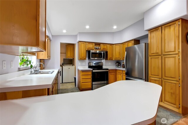 kitchen featuring brown cabinetry, a sink, light countertops, stainless steel appliances, and recessed lighting
