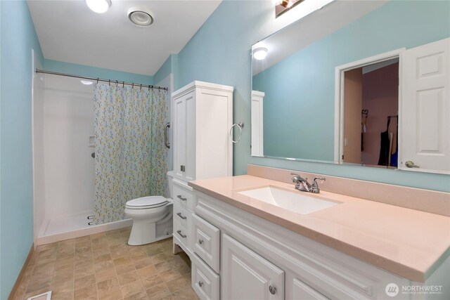 full bathroom featuring a shower with curtain, vanity, and toilet
