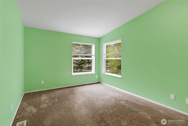carpeted empty room with baseboards and visible vents