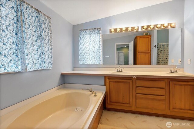 bathroom featuring a sink, double vanity, a bath, and lofted ceiling