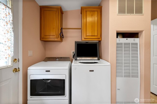 laundry area featuring visible vents, washer and clothes dryer, cabinet space, and a heating unit